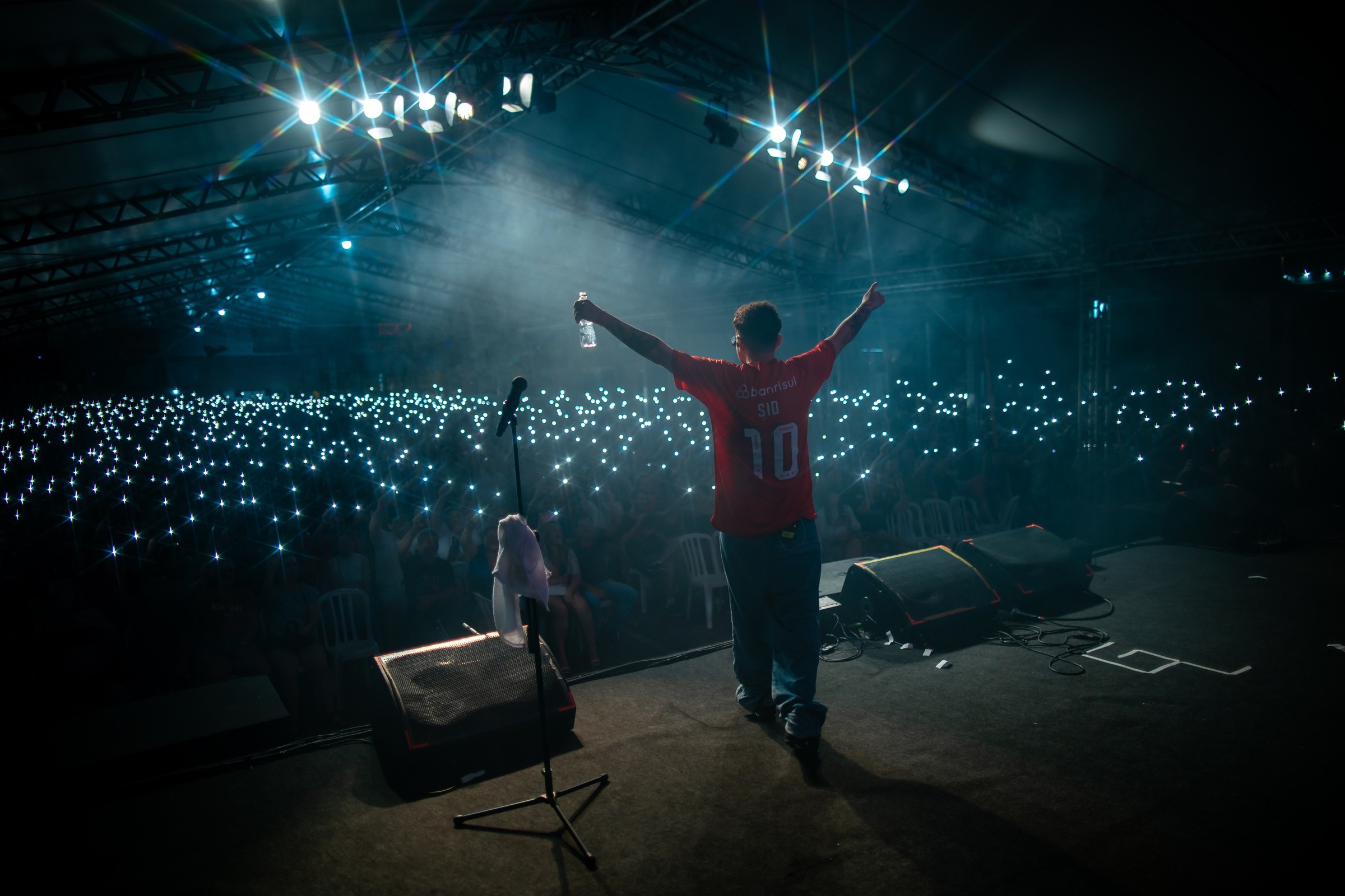 Plateia lotada com celulares iluminados em show do Gio Lisboa